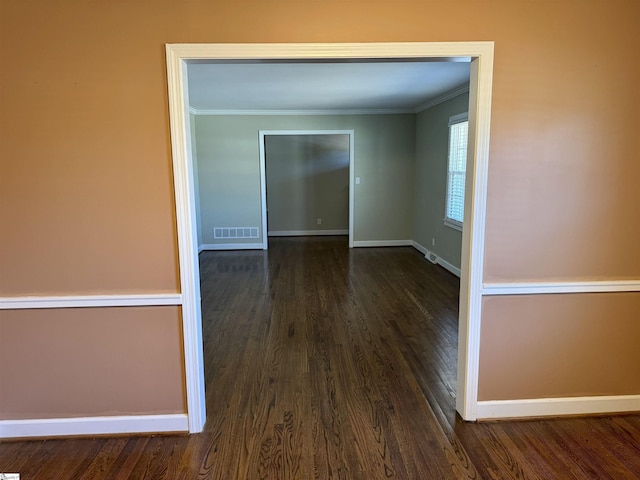 spare room featuring ornamental molding and dark hardwood / wood-style floors