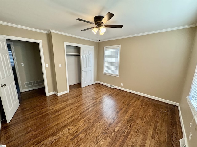 unfurnished bedroom featuring a closet, ornamental molding, dark hardwood / wood-style floors, and ceiling fan