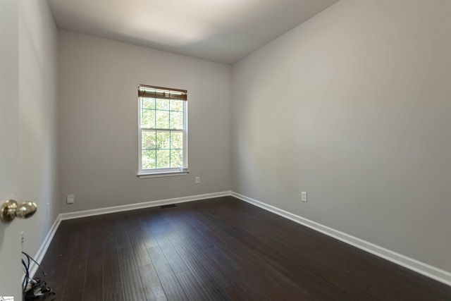 spare room with dark hardwood / wood-style flooring