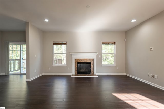 unfurnished living room featuring dark hardwood / wood-style flooring and a premium fireplace