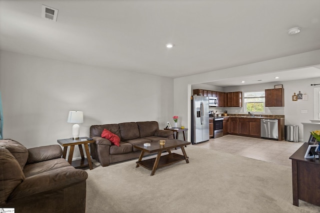 carpeted living room featuring sink