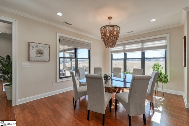 dining area featuring hardwood / wood-style flooring, ornamental molding, a water view, and a notable chandelier