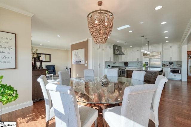 dining room featuring crown molding, dark hardwood / wood-style flooring, sink, and a chandelier