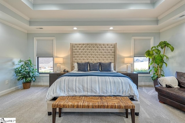 carpeted bedroom with ornamental molding and a tray ceiling