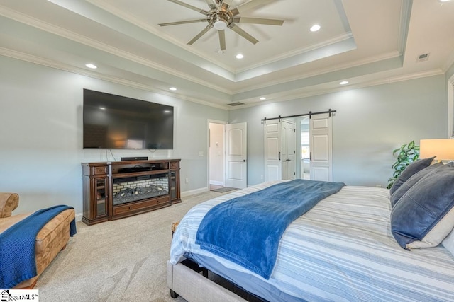 bedroom with crown molding, ceiling fan, a raised ceiling, light colored carpet, and a barn door