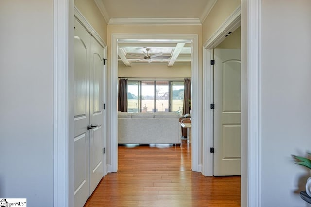 corridor with coffered ceiling, ornamental molding, beamed ceiling, and light wood-type flooring