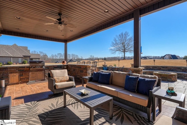 view of patio with ceiling fan, grilling area, an outdoor hangout area, and exterior kitchen