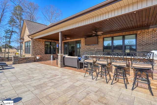 view of patio featuring an outdoor bar and ceiling fan