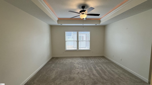 spare room with crown molding, ceiling fan, a raised ceiling, and carpet