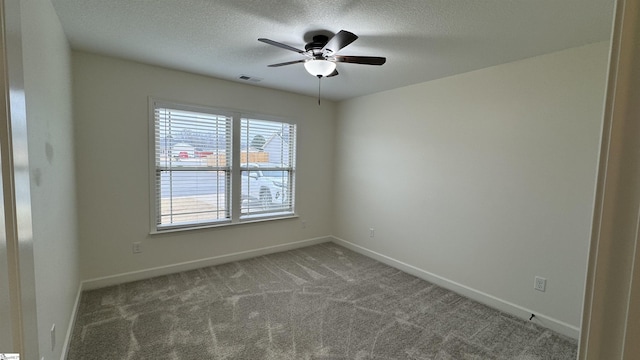 carpeted spare room with ceiling fan and a textured ceiling