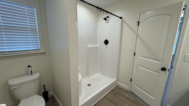 bathroom with walk in shower, toilet, and hardwood / wood-style flooring