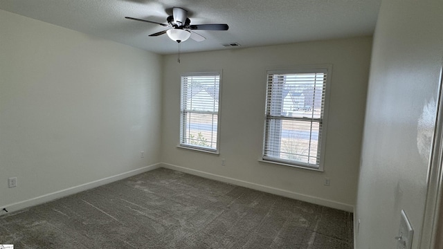 carpeted empty room with ceiling fan and a textured ceiling