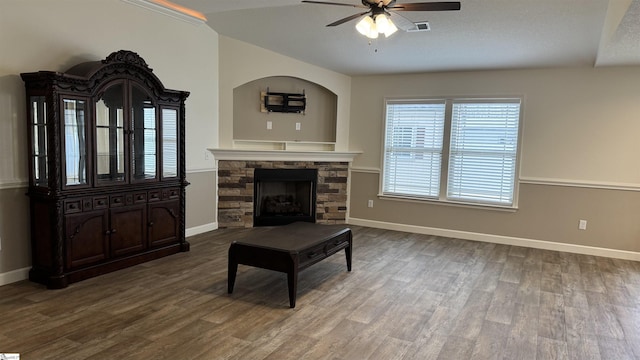 living room featuring wood-type flooring, lofted ceiling, ceiling fan, and a fireplace