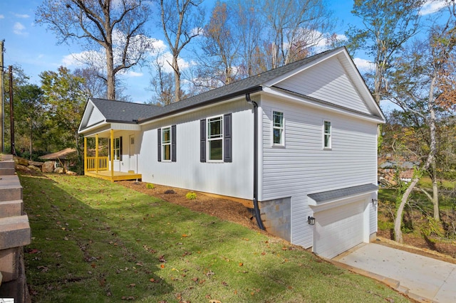 view of side of home featuring a garage, covered porch, and a lawn