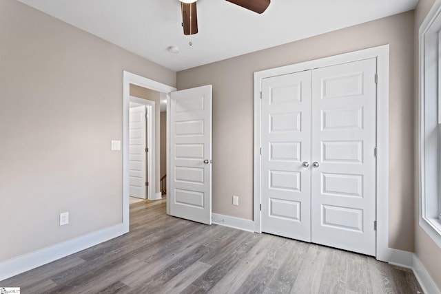 unfurnished bedroom featuring ceiling fan, light hardwood / wood-style floors, and a closet