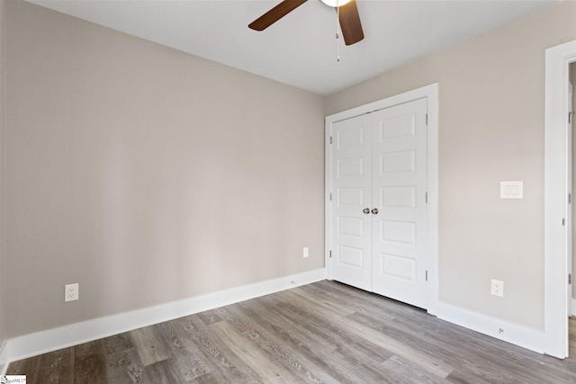 unfurnished bedroom featuring light hardwood / wood-style flooring, ceiling fan, and a closet