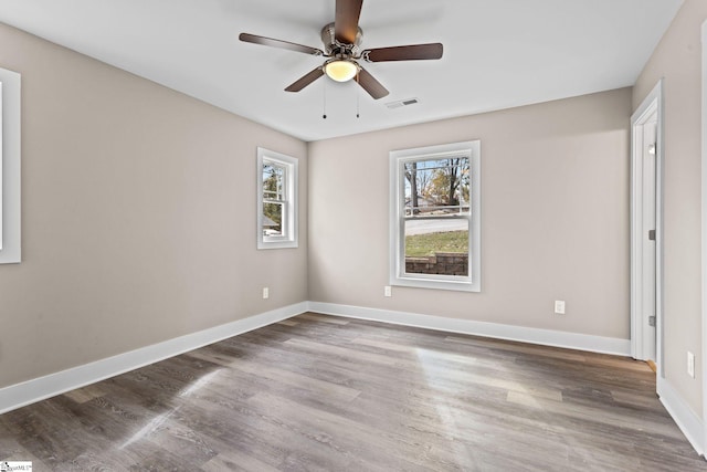 spare room with dark wood-type flooring and ceiling fan