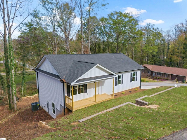 view of front of home featuring central AC, covered porch, and a front yard