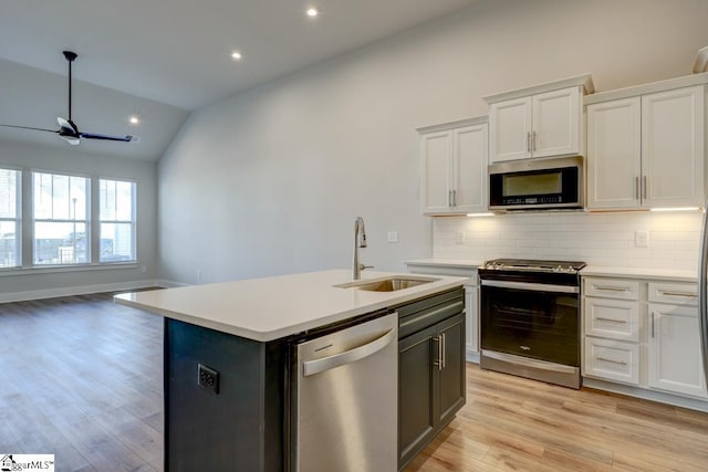 kitchen featuring sink, white cabinetry, stainless steel appliances, a center island with sink, and vaulted ceiling