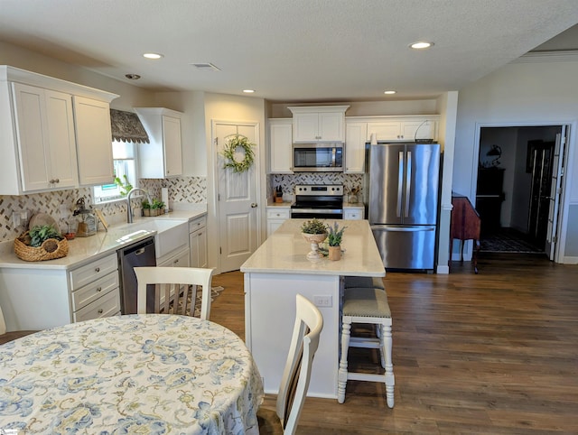 kitchen featuring white cabinetry, appliances with stainless steel finishes, a center island, and dark hardwood / wood-style floors