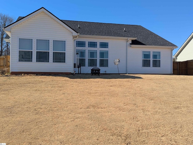 back of property featuring a lawn and a fire pit