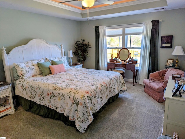 bedroom with a raised ceiling, ornamental molding, light colored carpet, and ceiling fan