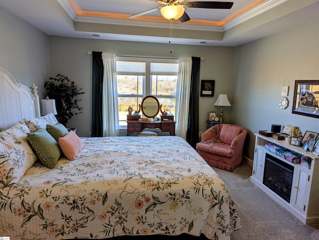 bedroom featuring crown molding, light colored carpet, a tray ceiling, and ceiling fan