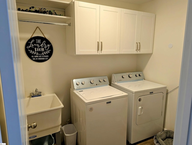 clothes washing area featuring cabinets, sink, and independent washer and dryer