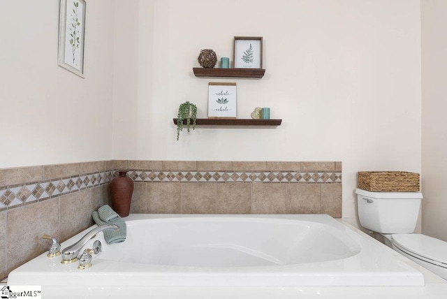 bathroom featuring a tub to relax in and toilet