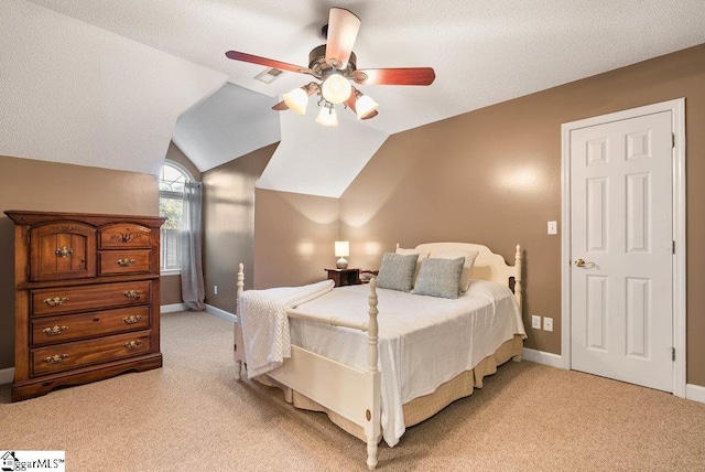 carpeted bedroom with ceiling fan, lofted ceiling, and a textured ceiling