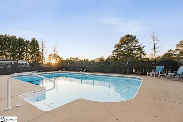 pool at dusk featuring a patio area