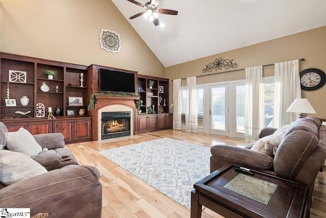 living room with ceiling fan, wood-type flooring, and high vaulted ceiling