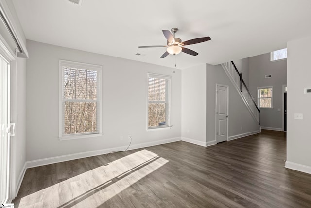 empty room featuring dark wood-type flooring, ceiling fan, and plenty of natural light