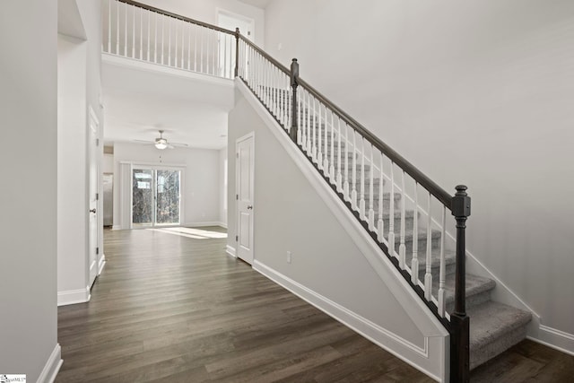 stairs with hardwood / wood-style flooring and a high ceiling