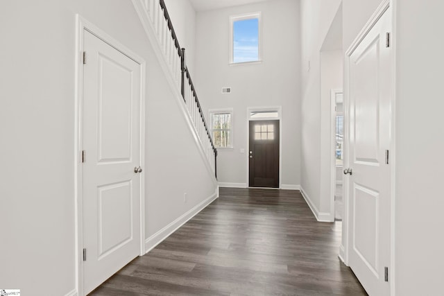 foyer featuring dark hardwood / wood-style floors and a towering ceiling