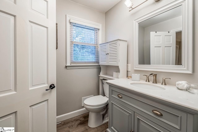 bathroom with hardwood / wood-style flooring, vanity, and toilet