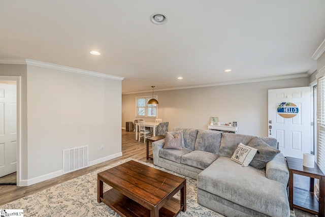 living room with crown molding and light hardwood / wood-style floors