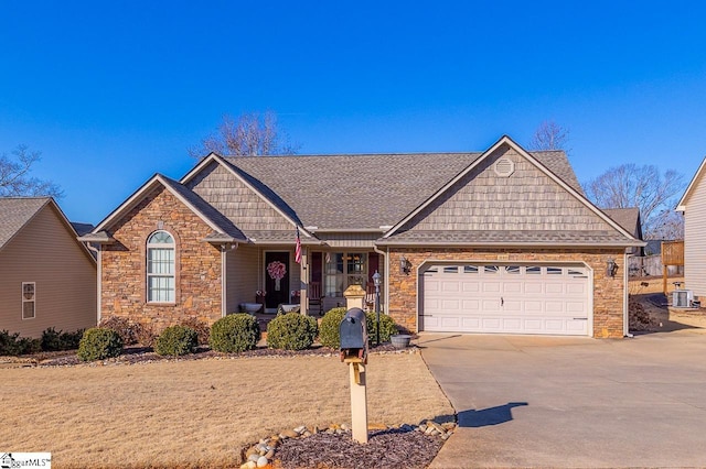 single story home with a garage, cooling unit, and covered porch