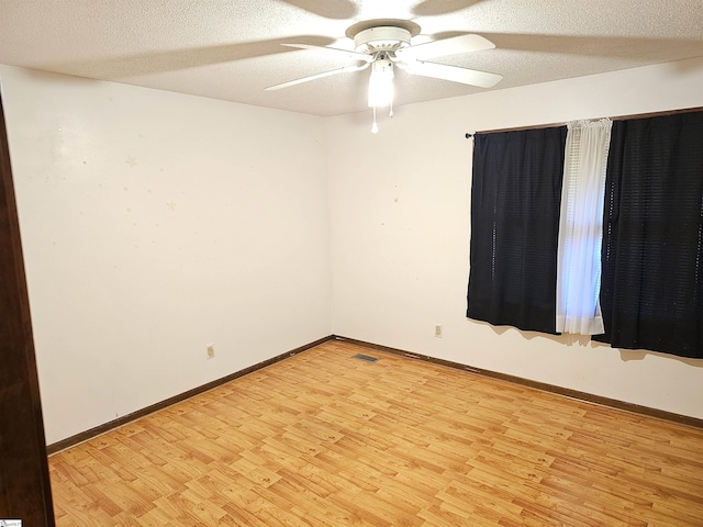 empty room with ceiling fan, a textured ceiling, and light hardwood / wood-style floors