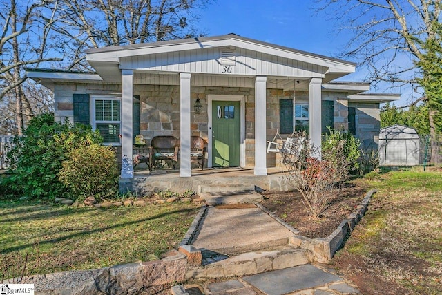 view of exterior entry with a porch and a yard