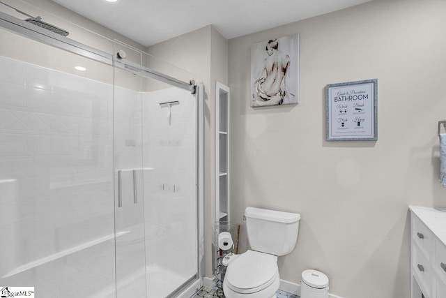 bathroom with a shower with door, vanity, and toilet