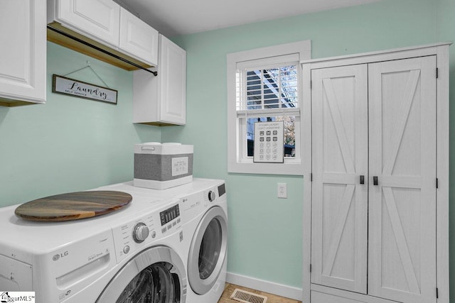 clothes washing area featuring cabinets and independent washer and dryer