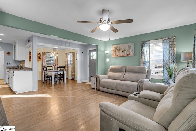 living room with ceiling fan and light hardwood / wood-style flooring