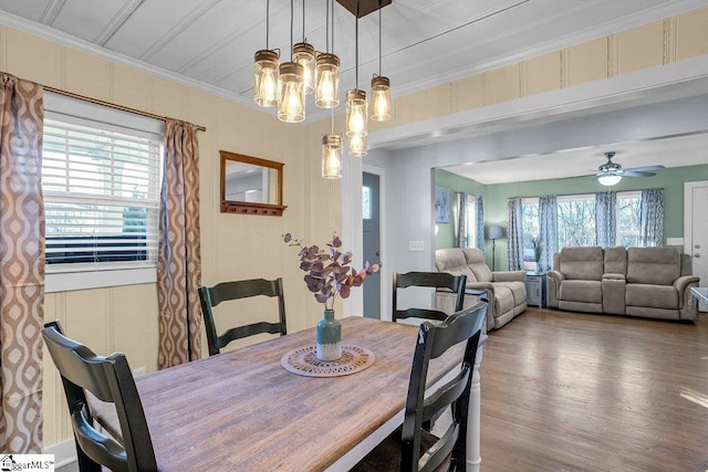 dining area featuring ceiling fan with notable chandelier, ornamental molding, and hardwood / wood-style floors