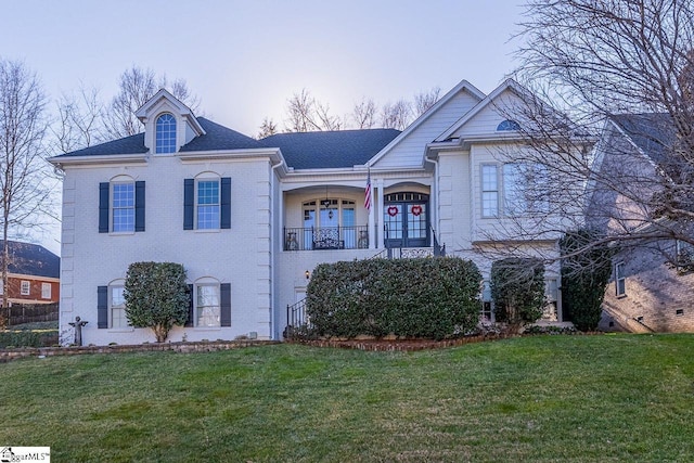 view of front of home featuring a yard and a balcony