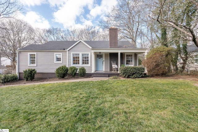 ranch-style home featuring a front lawn and covered porch