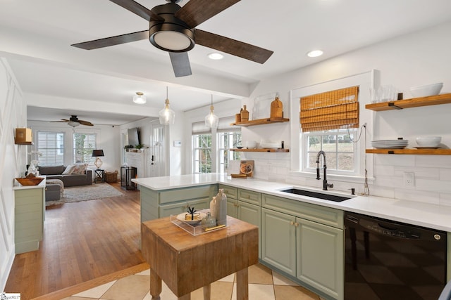 kitchen with pendant lighting, dishwasher, sink, backsplash, and green cabinetry