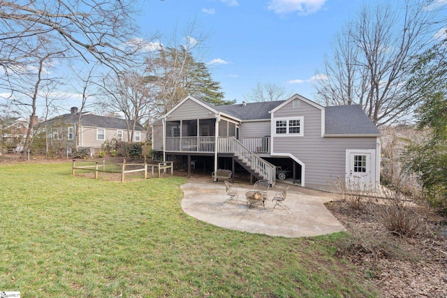 rear view of property with a fire pit, a patio area, a sunroom, and a lawn