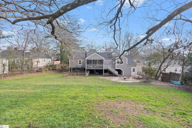 back of house with a yard, a sunroom, and a patio