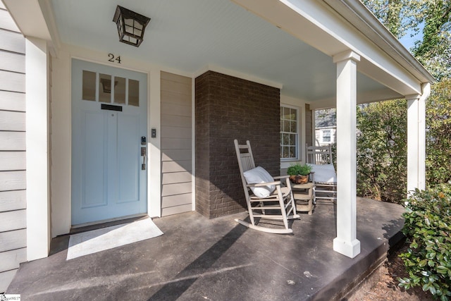 view of exterior entry with elevator and covered porch